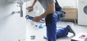 Plumber replacing sink pipes during preventive plumbing service